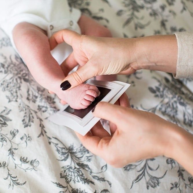 A dynamic shot of a baby’s foot being pressed onto an ink pad