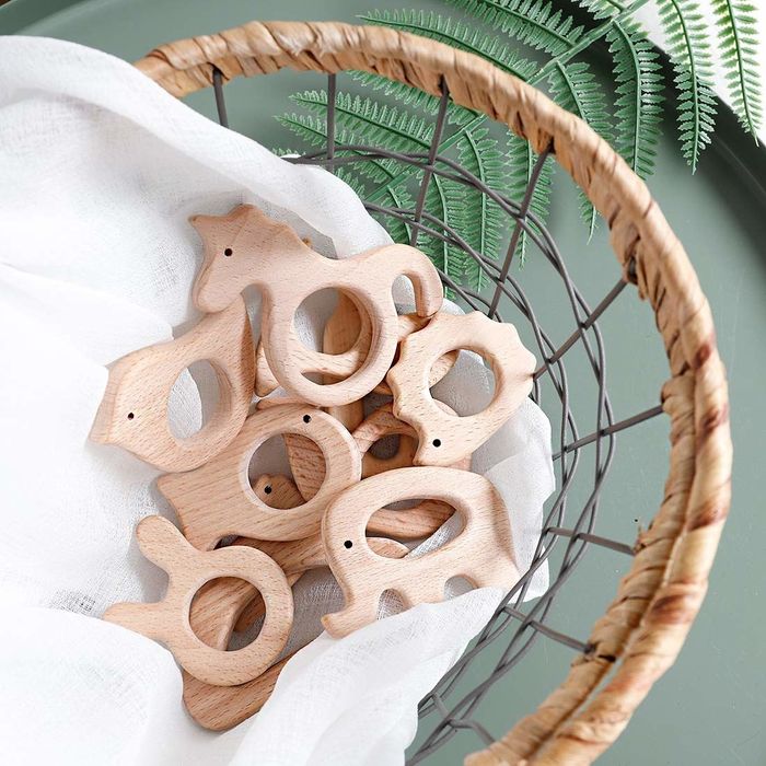 A basket containing animal-shaped teethers crafted from natural wood