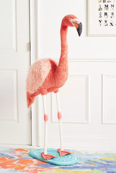 A freestanding flamingo doll placed in a bedroom