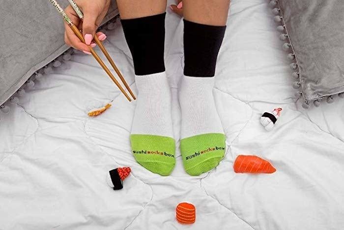 A model showcases a pair of socks from the set while holding chopsticks.