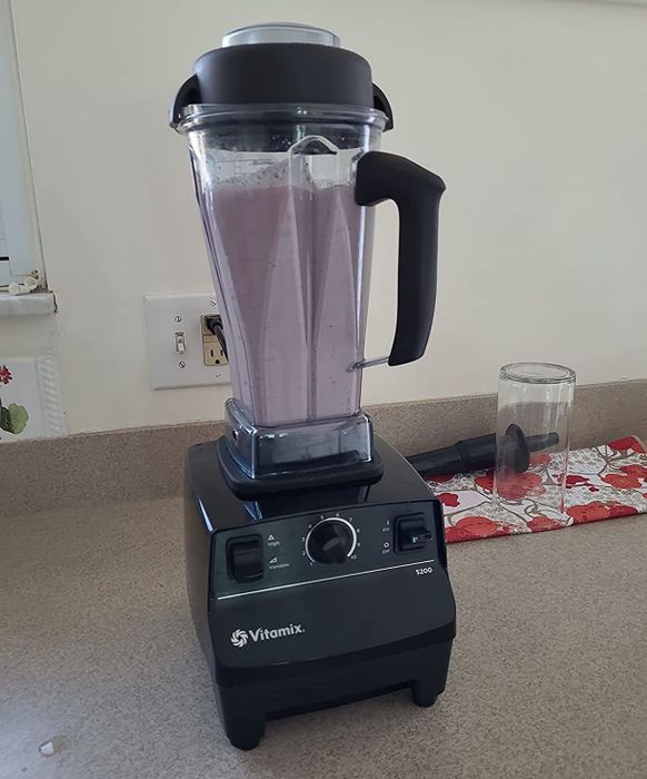 A reviewer’s Vitamix blender filled with a vibrant purple smoothie