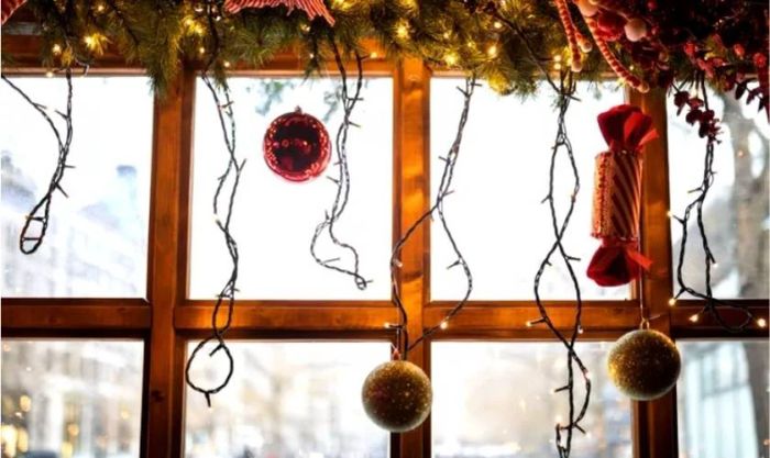 Treo các quả châu để trang trí cửa kính Noel