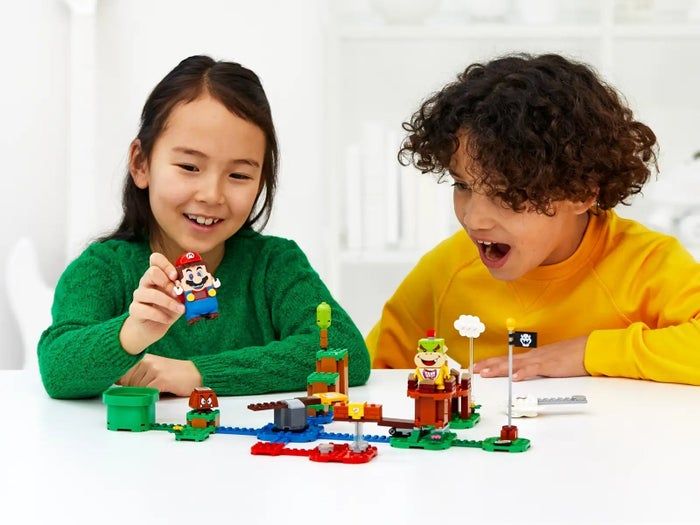 Children engage with a Mario Lego set, enjoying both the construction and play experience. It's a great way for kids to interact with their favorite character in a hands-on way, while also promoting creative play and exploration.