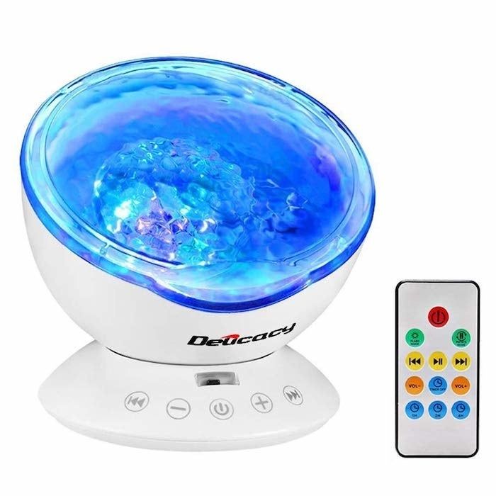 The projector features a circular top that lights up in a variety of colors, paired with a base that has buttons for easy operation.
