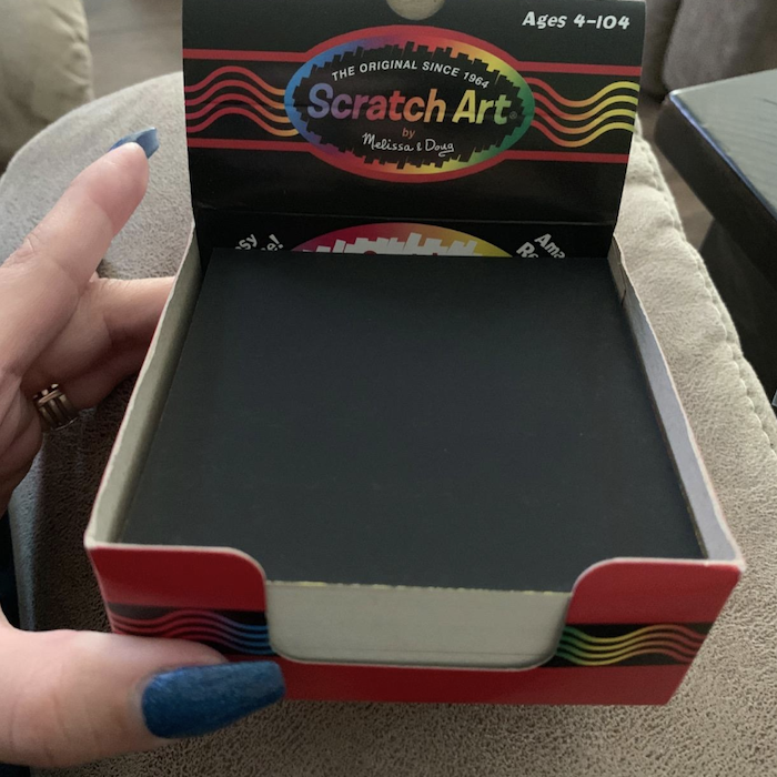 A reviewer holds a box of black sticky notes, ready to be transformed into colorful creations.