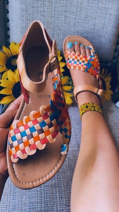 A model showcasing the sandals in a vibrant rainbow design.