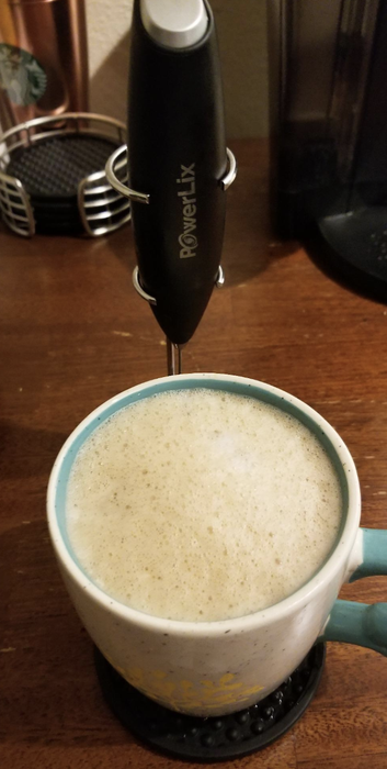 A steaming mug filled with frothy coffee.