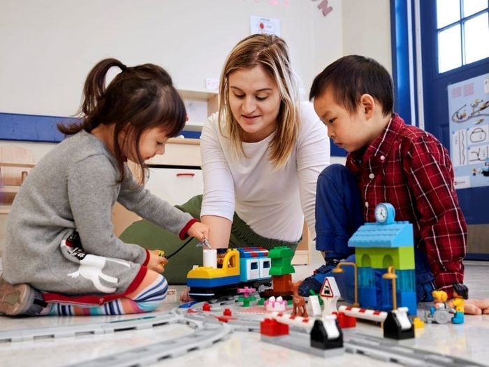 An adult and child having fun together with the train set.