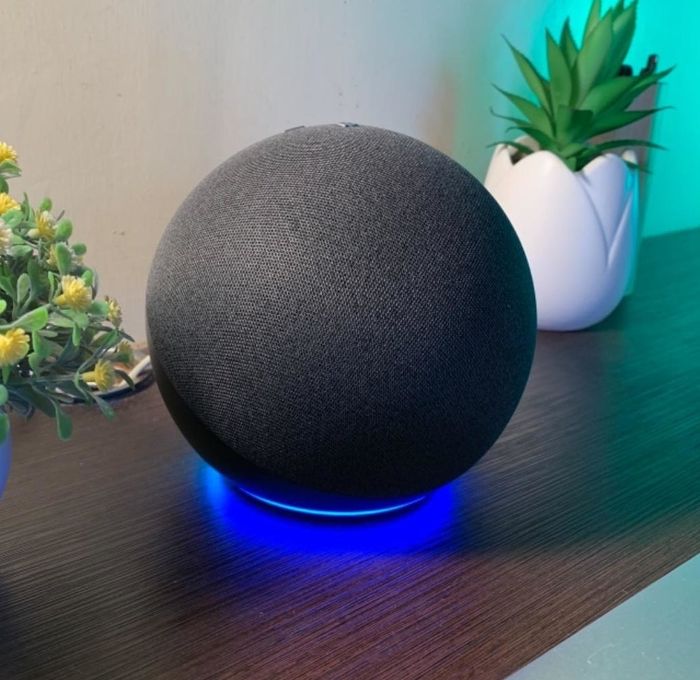 A reviewer’s black Echo speaker placed on a desk, emitting a soft blue glow from its base