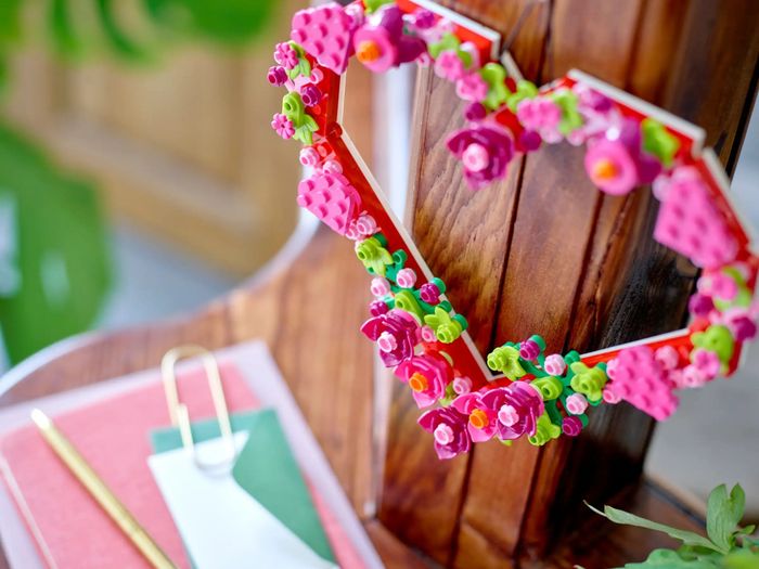 A Lego heart wreath is displayed on a wall.