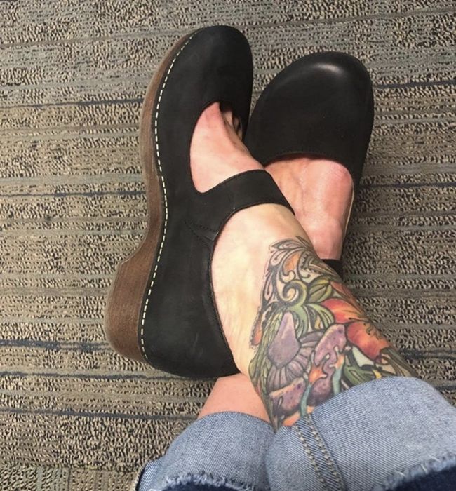 A reviewer's picture featuring the black clogs with brown soles.