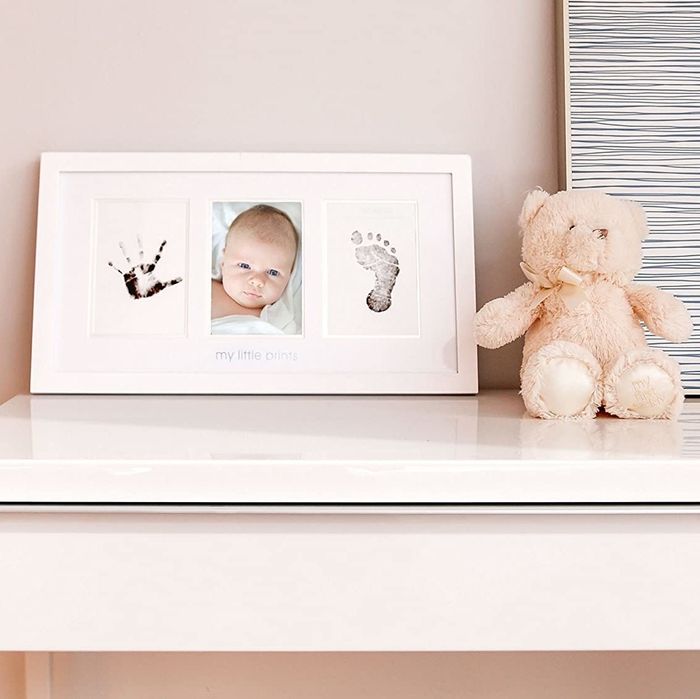 A long frame displaying three images: a printed hand, a baby's face, and a printed foot