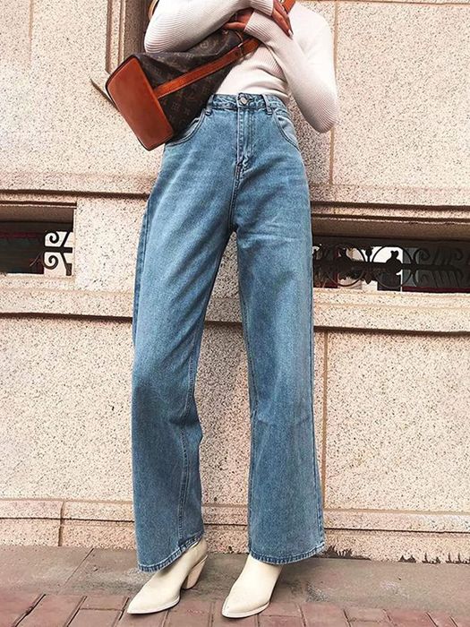 A model wearing high-waisted blue wide-leg jeans.