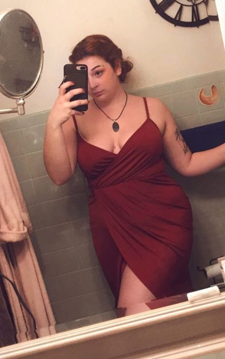 Reviewer snapping a selfie in a vibrant red dress