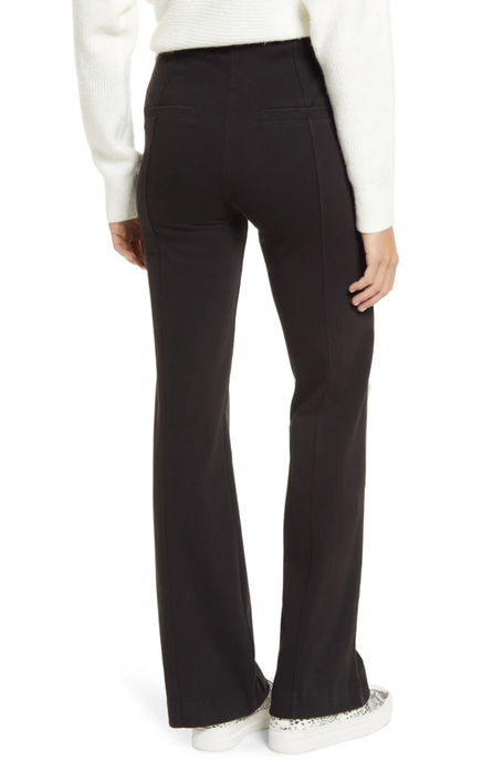 A model showcases the back view of the product while wearing a white sweater.