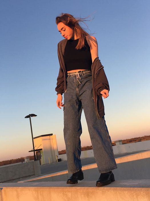 A reviewer wearing blue wide-leg jeans with deep, spacious pockets.