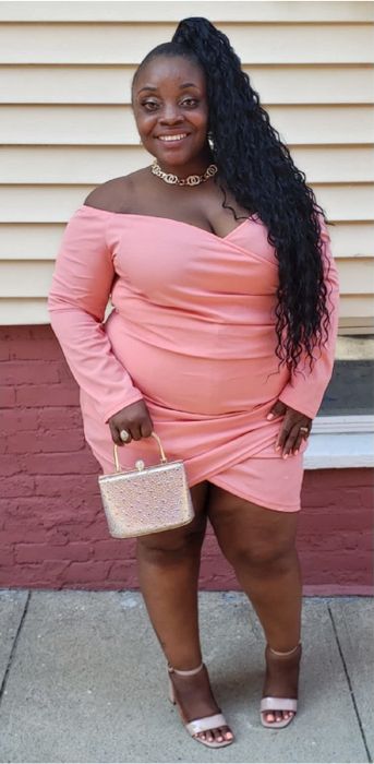 a reviewer wearing the pink version of the dress