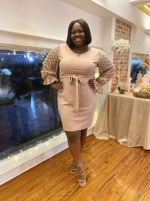 a reviewer wearing the pink version of the dress