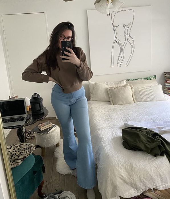 a reviewer modeling the light blue jeans