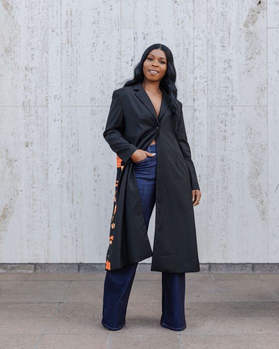 A model dressed in deep blue wide-leg jeans paired with a long black blazer.