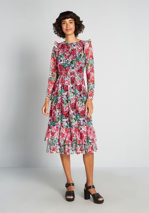 a model wearing the long-sleeved pink floral midi dress