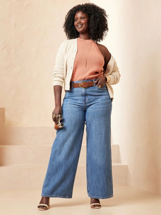A model striking a pose in wide-leg blue jeans.
