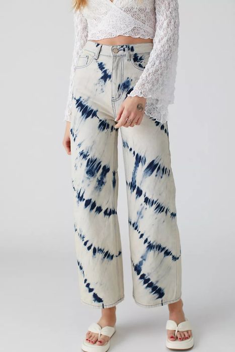 The front view of a model wearing blue and white tie-dye jeans.