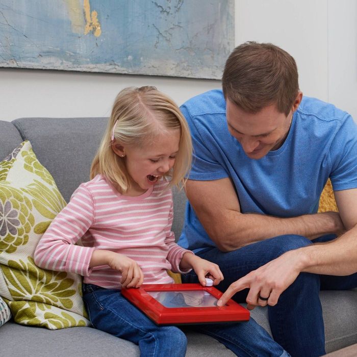 Parent and child using an Etch A Sketch together