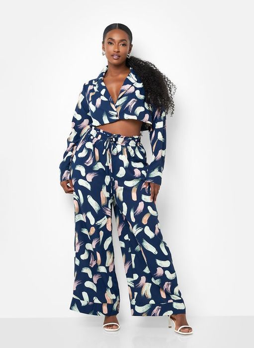 Model in a patterned top paired with wide-leg trousers