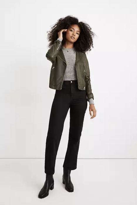A model rocking straight wide-leg jeans, paired with a green jacket and black boots.