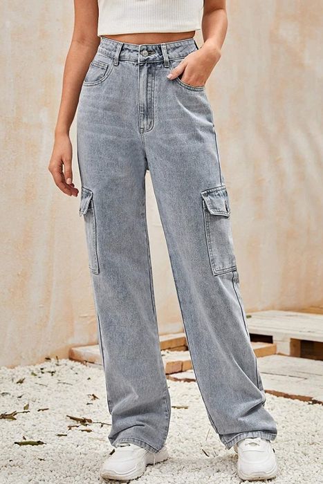 A model wearing gray baggy jeans with cargo pockets paired with white sneakers.