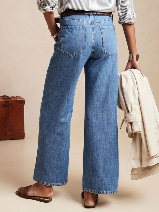 The back view of a model wearing wide-leg blue jeans.