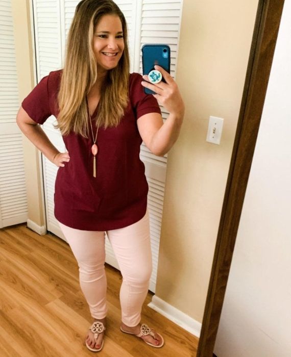 A reviewer showcasing the pale pink jeans