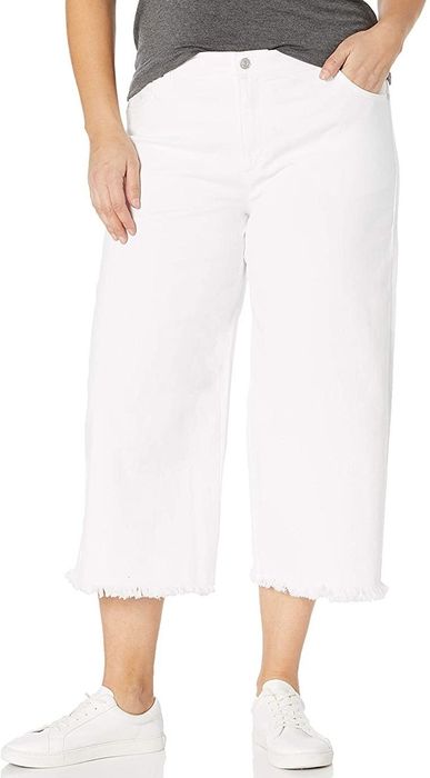 A model styling white cropped wide-leg jeans with a frayed hem.