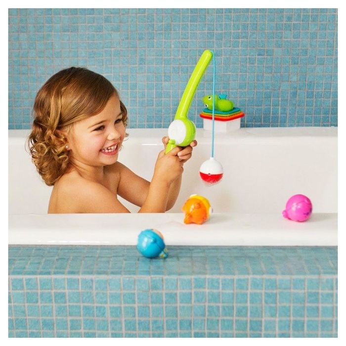 Child playing with a fishing toy in the bath