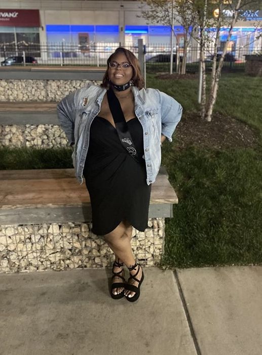 Reviewer in a black dress layered with a denim jacket