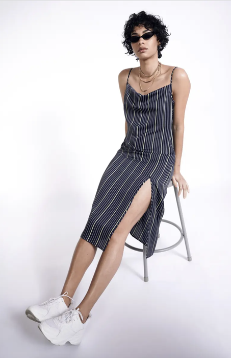 model wearing the slip dress, highlighting the square neckline and vertical blue and green stripes