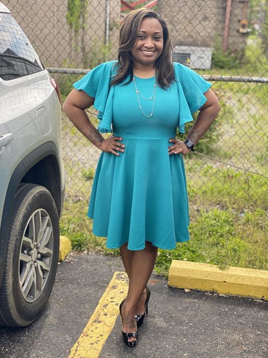 a reviewer wearing the teal version of the dress