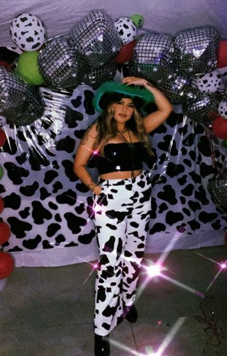 a reviewer modeling the black and white cow-print pants