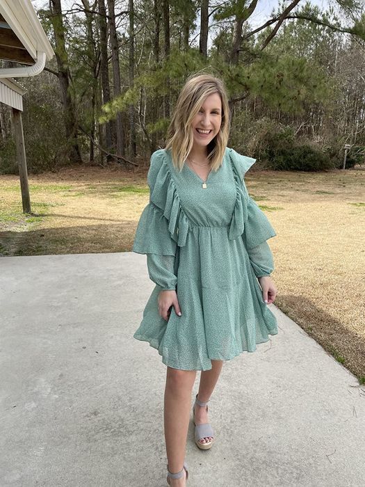 reviewer showcasing the green version of the dress