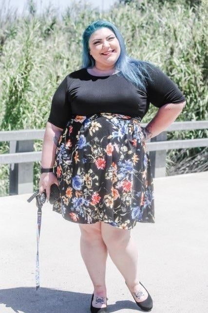 a reviewer wearing the black floral version of the dress