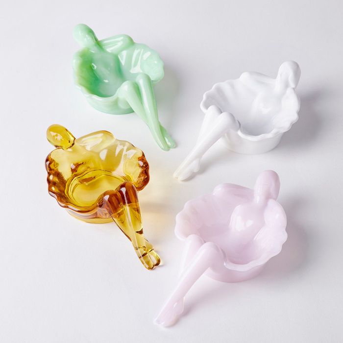 Four glass dishes shaped like a bathing woman.
