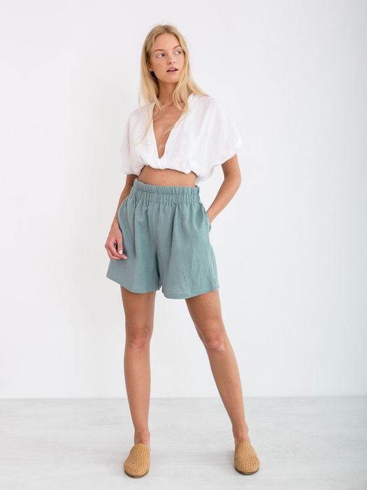 Model showcasing the mid-thigh length elastic-waisted shorts in blue