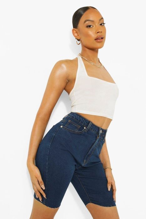 A close-up of a model wearing denim biker shorts paired with a tank top.