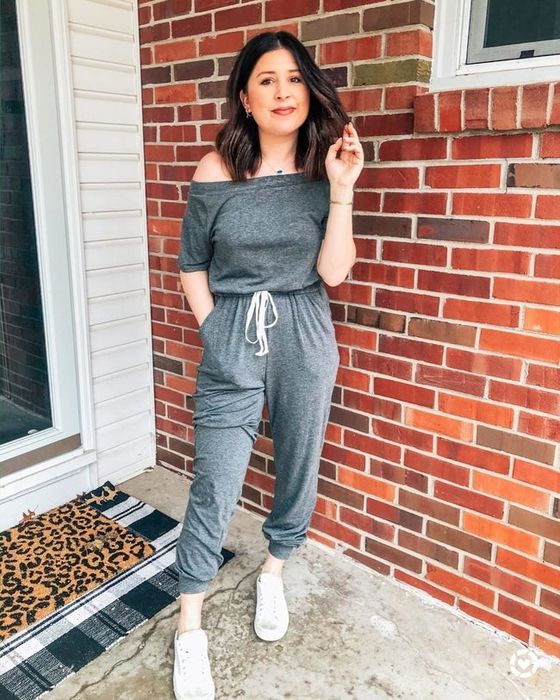 A reviewer modeling the grey jumpsuit