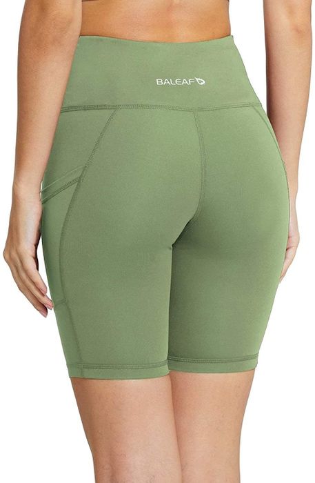 A model is showing off green shorts.