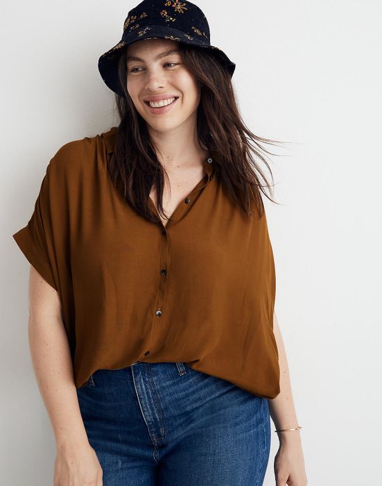 A plus-size model showing off the button-up short-sleeve shirt in tobacco color