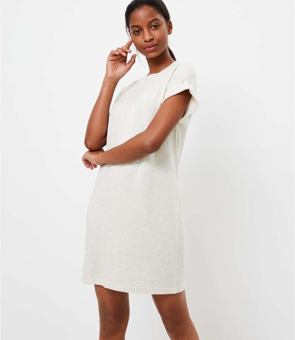 A model wearing a cream dress with cap sleeves