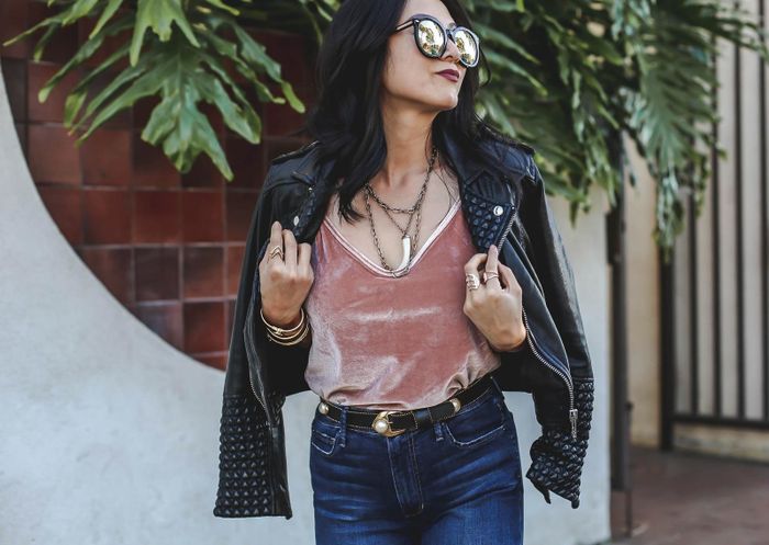 A reviewer showcasing the pink cami, styled with jeans and a leather jacket