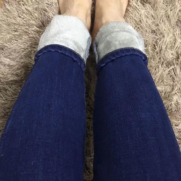The same reviewer rolling up the jeans to reveal the cozy fleece interior